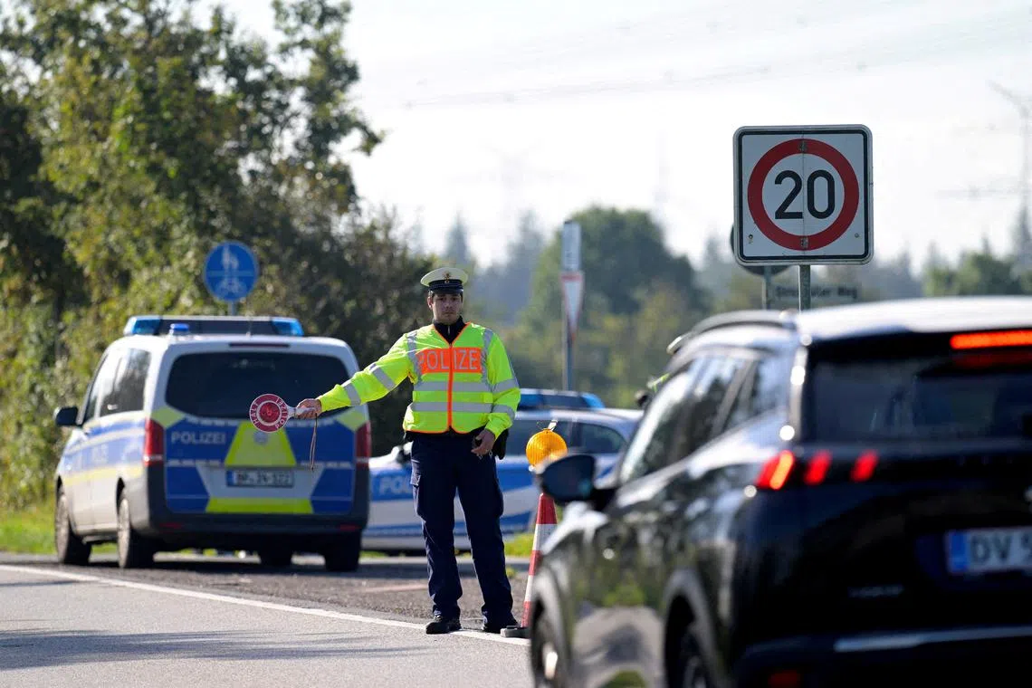 FILE PHOTO: A police officer holds a stop sign at a border with Denmark, as all German land borders are subject to random controls to protect internal security and reduce irregular migration, in Boeglum, Germany, September 16, 2024. REUTERS/Fabian Bimmer/File Photo