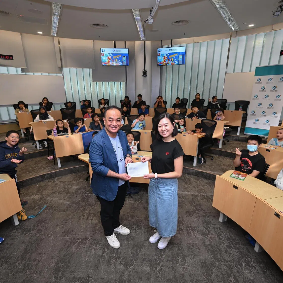 Gilbert Pak, Chief Marketing Officer of Tokio Marine Life Insurance Singapore presenting a $10,000 donation to The Straits Times Pocket Money Fund (STSPMF) general manager Lau Hui Ling on Dec 2, 2025.