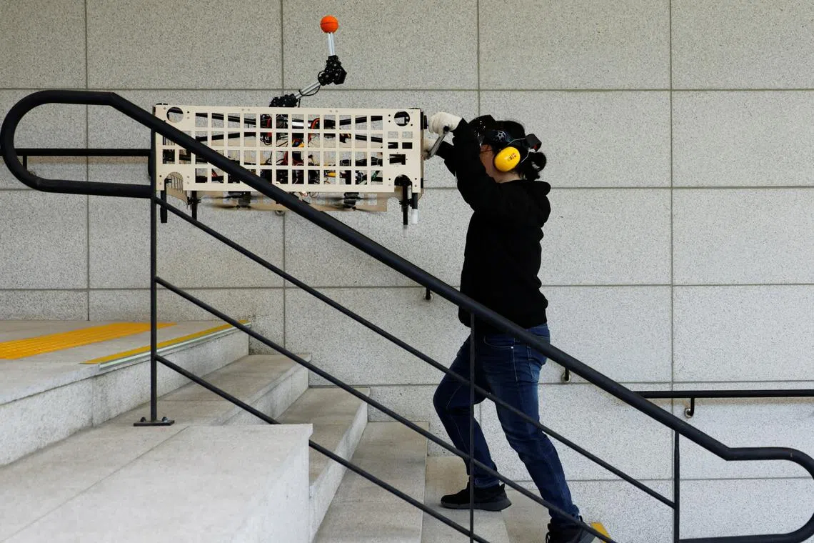 Graduate student Park Hyun-geun demonstrates the aerial transportation platform 'Palletrone' on stairs at the Seoul Tech in Seoul, South Korea.