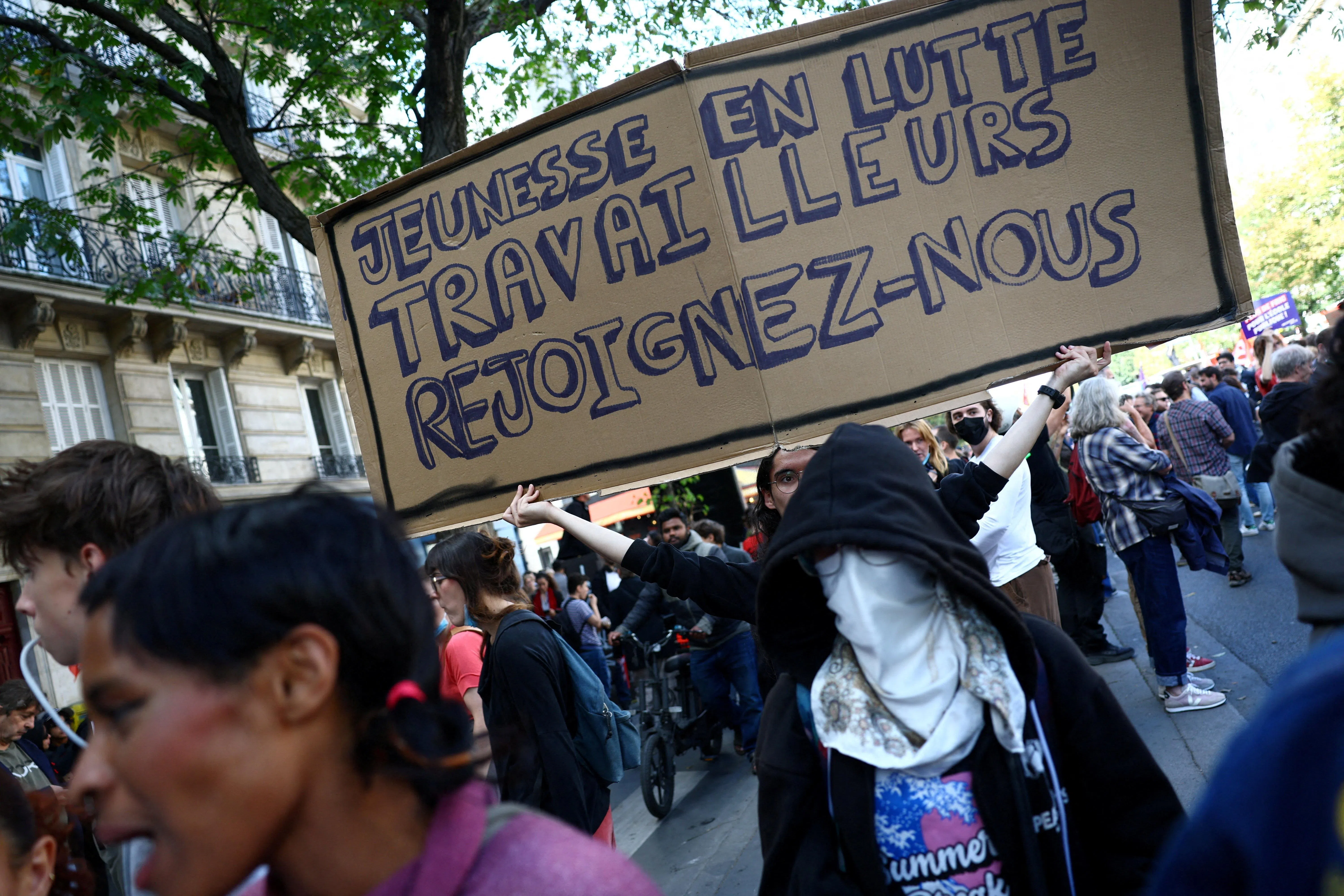 A protester holding a placard on Oct 6 that reads “Youth in struggle, workers join us” during a demonstration in Paris.