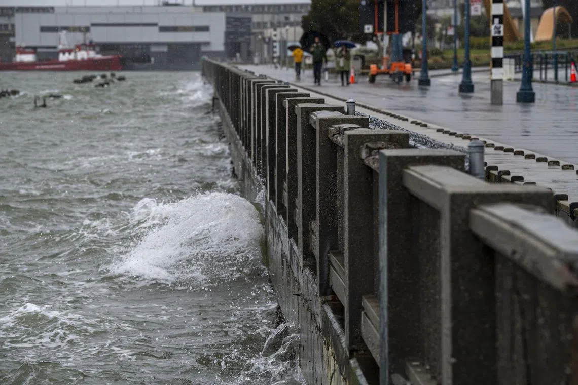 Water breaks on the seawall along the Embarcadero during a rain storm in San Francisco, California, on March 9, 2023. 