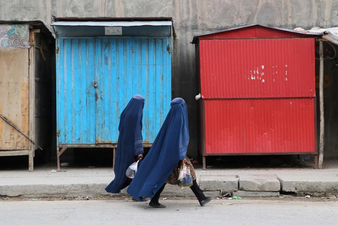 Afghan burqa-clad women walk along a street in Badakhshan, Afghanistan, on Feb 5, 2023.
