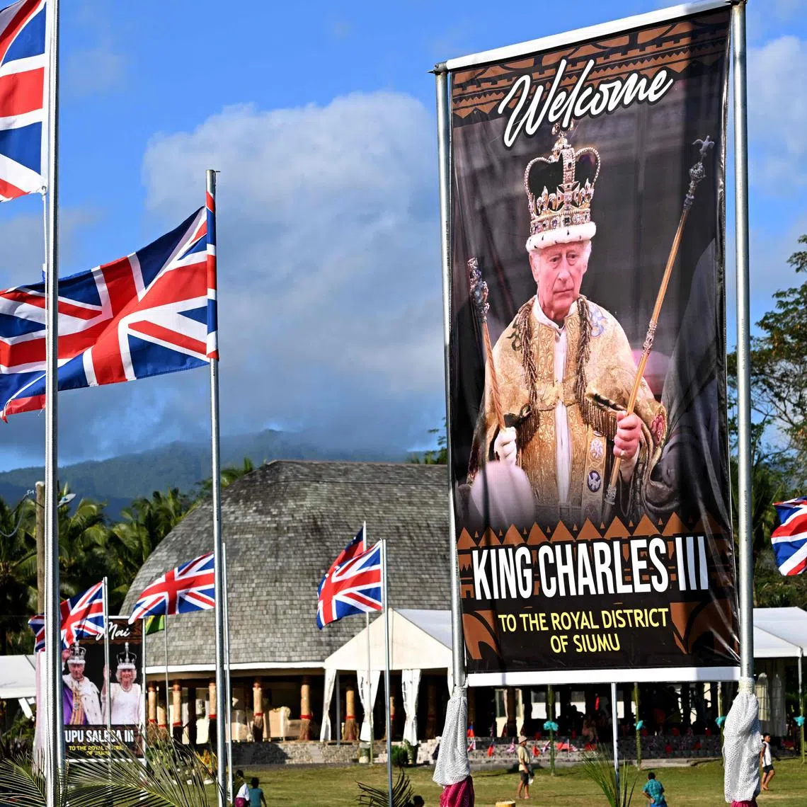 Children play rugby near a portrait of Britain's King Charles III in the village of Siumu on Oct 22.