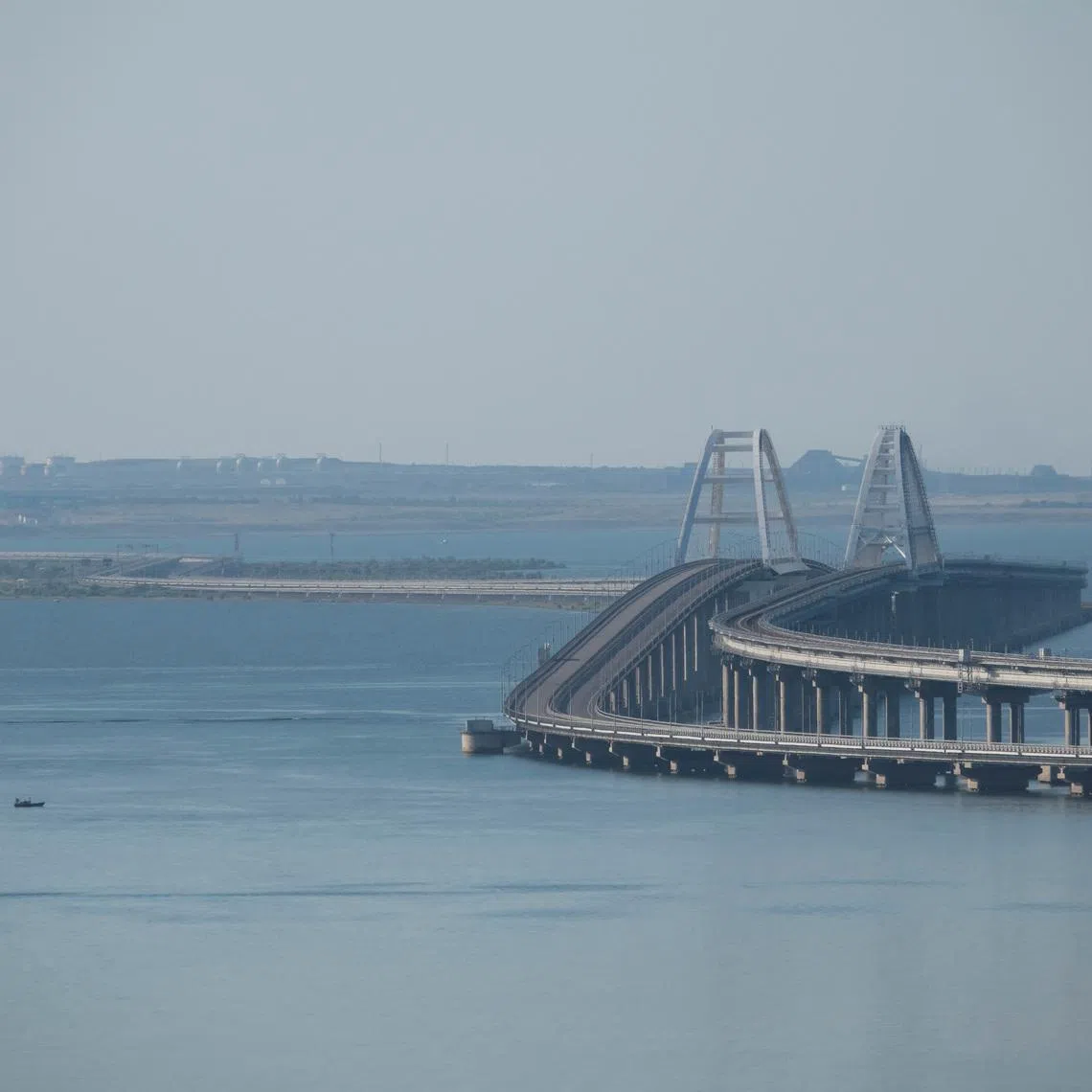 A boat sails next to the Crimean bridge connecting the Russian mainland with the peninsula across the Kerch Strait, Crimea, July 17, 2023.  REUTERS/Stringer
