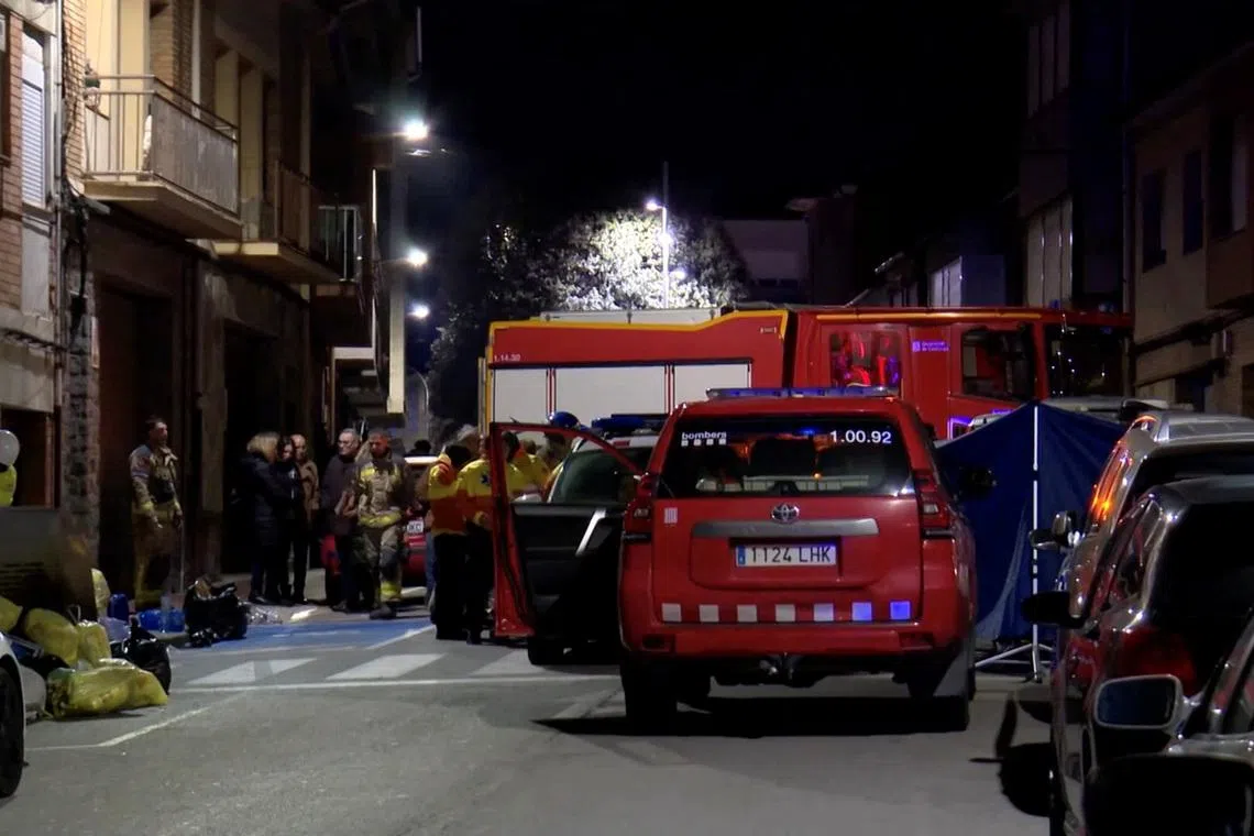 Emergency personnel stand outside an apartment building that caught fire and killed five young people, in Manlleu, in the Catalonia region, Spain, in this screen grab taken from a video obtained on February 17, 2026. FORTA/Handout via REUTERS