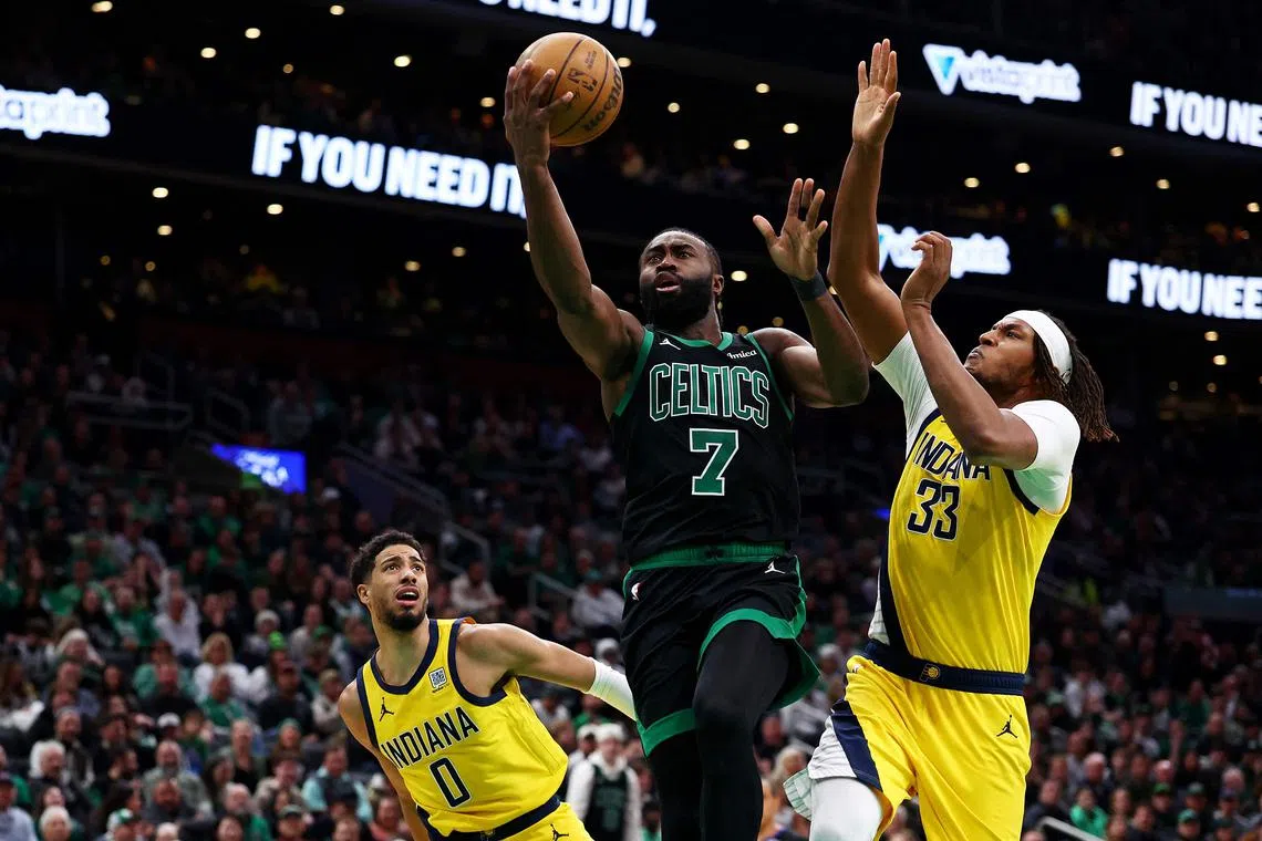 Jaylen Brown of the Boston Celtics takes a shot between Tyrese Haliburton and Myles Turner of the Indiana Pacers during the first quarter at TD Garden.