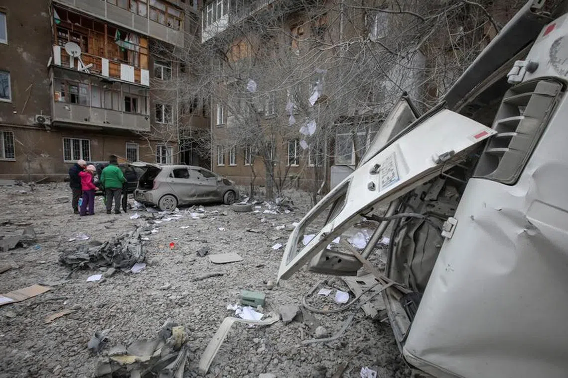Local residents stand near their apartment building and cars damaged during a Russian missile strike, amid Russia's attack on Ukraine, in Kharkiv, Ukraine December 8, 2023. REUTERS/Vyacheslav Madiyevskyy