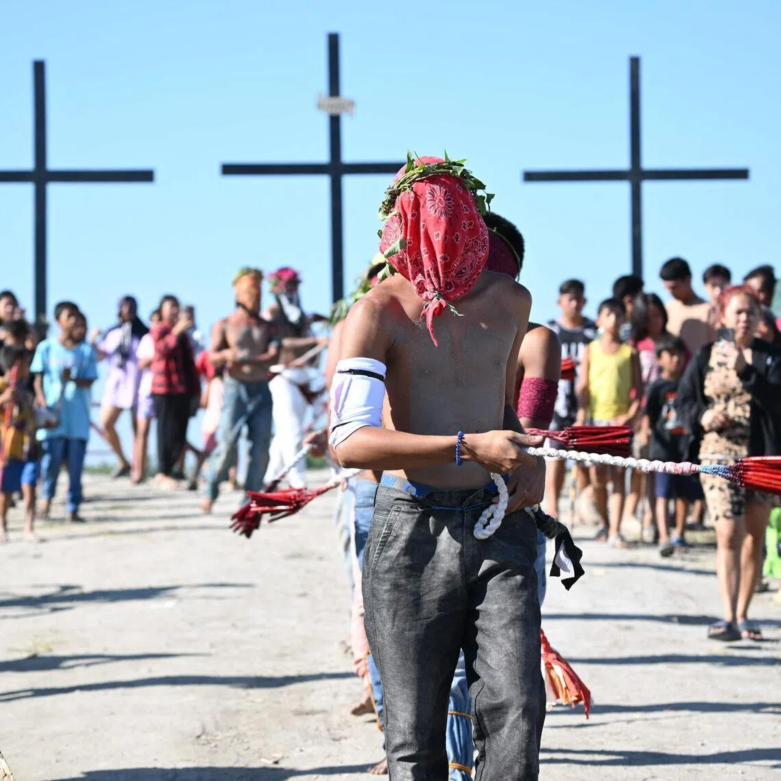 Penitents flagellate themselves as they walk to a mound with crosses prior to the annual crucifixion during the observance of Lent in the village of Cutud in San Fernando City.