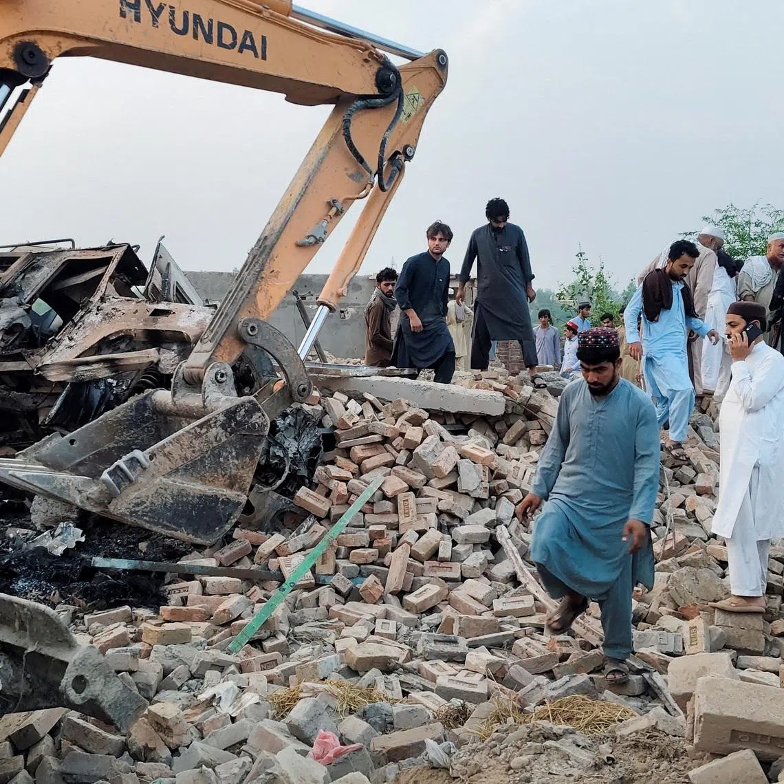 Residents gather on the rubble of a damaged police post after a car bombing on May 10.