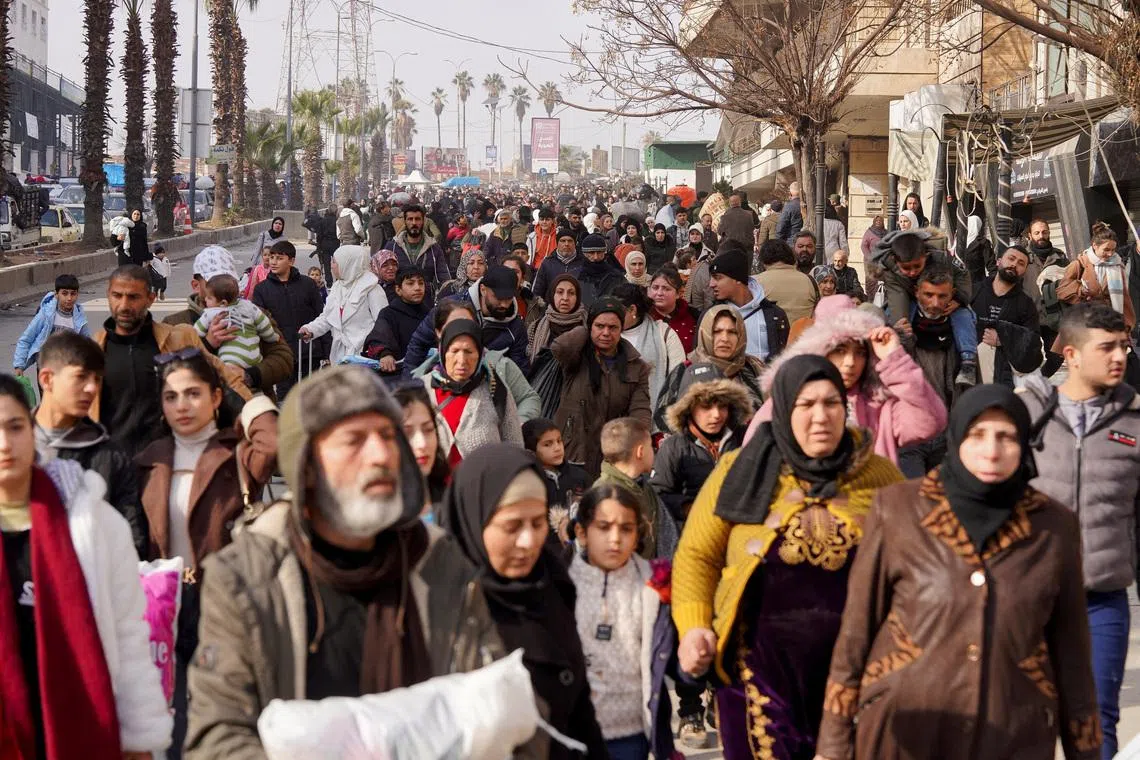 A group of civilians carry bags and belongings as they flee following renewed clashes between the Syrian army and the Syrian Democratic Forces, in Aleppo, Syria, January 7, 2026. REUTERS/Karam al-Masri