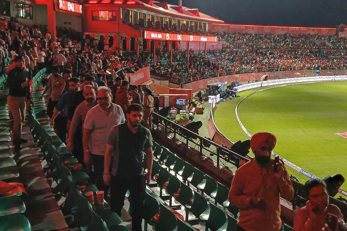 Spectators leave after the Indian Premier League (IPL) Twenty20 cricket match between Punjab Kings and Delhi Capitals was abandoned due to a significant technical failure at the Himachal Pradesh Cricket Association Stadium in Dharamshala on May 8, 2025.