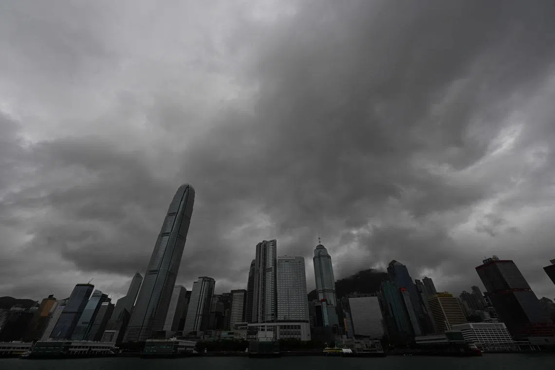 (FILES) Heavy rain clouds are seen over Central district as Hong Kong hoisted typhoon signal no 8 around noon on October 8, 2023 as typhoon Koinu skirted by after the financial hub was affected again by a super typhoon and historic rainstorm last month. Hong Kong's stock exchange will continue trading through typhoons and heavy storms from September, the city's leader announced on June 18, 2024. (Photo by Peter PARKS / AFP)