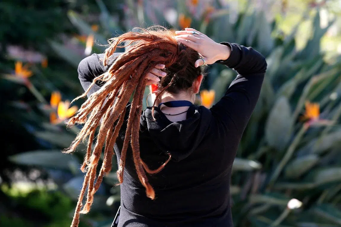 FILE PHOTO: A woman arranges her dreadlocked hair in a public square in Valparaiso, Chile October 11, 2017. REUTERS/Rodrigo Garrido/File Photo
