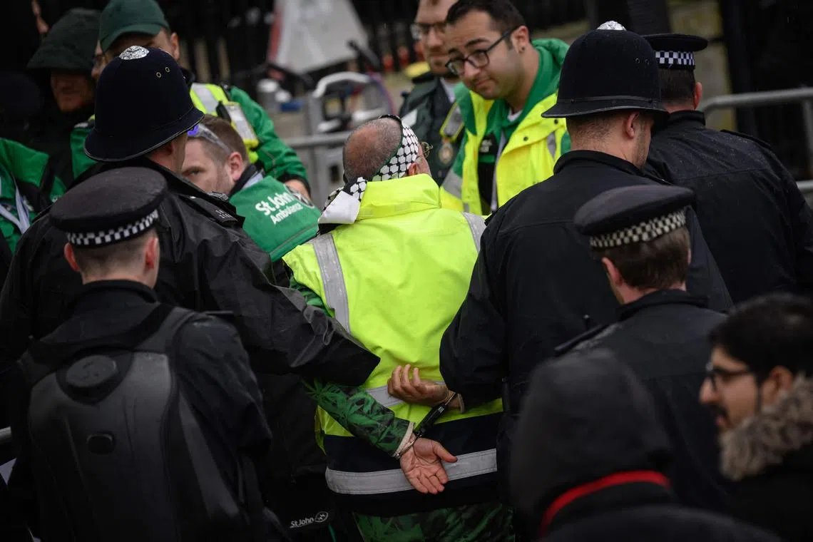 Police officers make an arrest close to the 'King's Procession', a journey of 2km from Buckingham Palace to Westminster Abbey in central London on May 6, 2023.