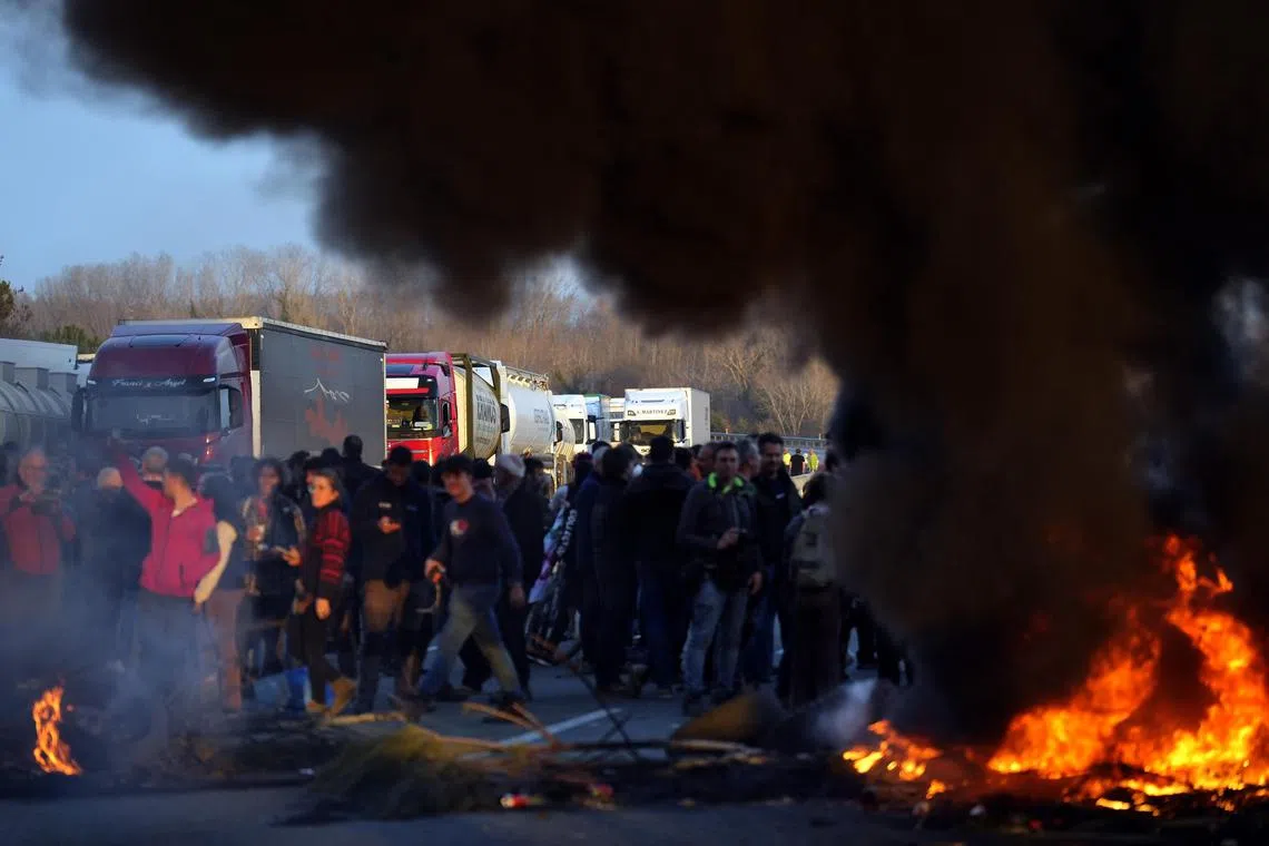 Farmers with their tractors blocking the motorway light fires during a protest in Girona, Spain, 6 Feb 2024. 