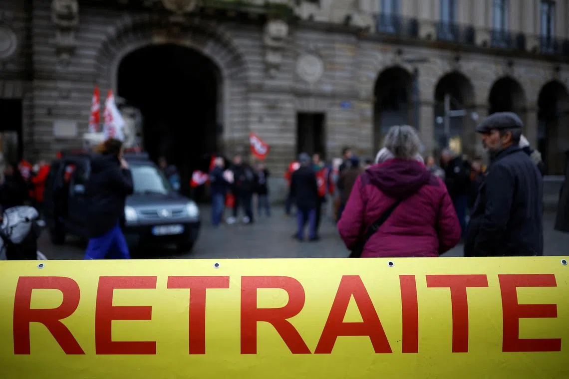 Protestors hold a banner which reads "retirement" during a demonstration against pension reform.