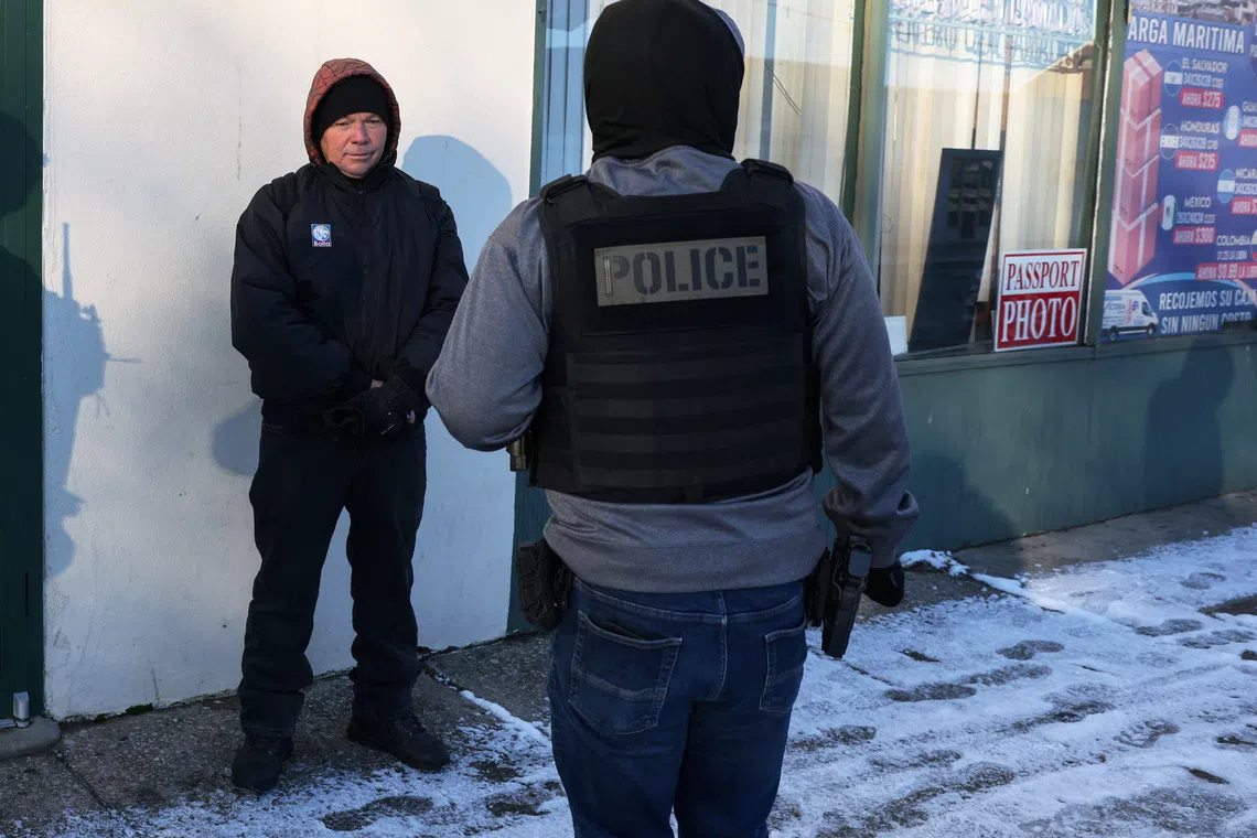 A Federal agent questions a man, who showed his Temporary Protected Status (TPS) and had came to the U.S. 25 years ago from El Salvador, during immigration removal operations in the Long Island town of Hempstead, New York, U.S., January 19, 2026. REUTERS/Shannon Stapleton