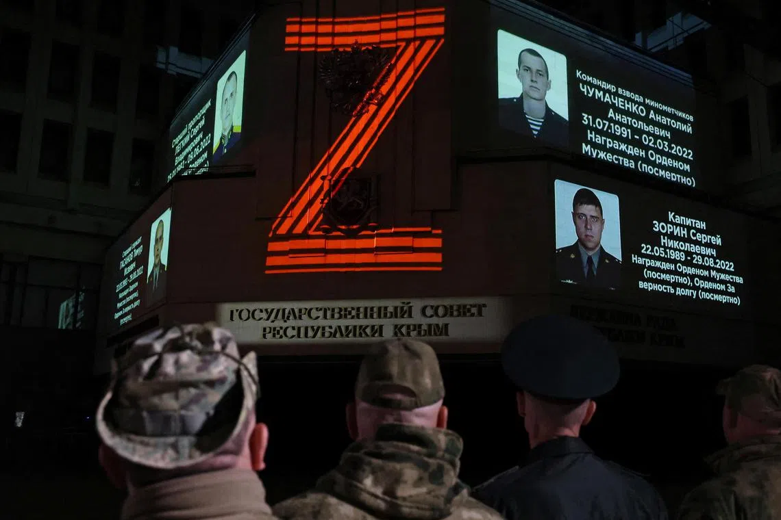 Portraits of Russian service members killed in Russia-Ukraine conflict and the symbol "Z" are projected onto the State Council building in Simferopol, Crimea, on April 8, 2024.