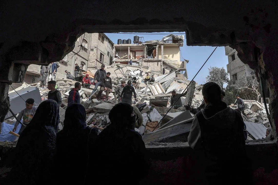 Palestinians checking the rubble of buildings that were destroyed following overnight Israeli bombardment in Rafah, in the southern Gaza Strip, on March 27, 2024.