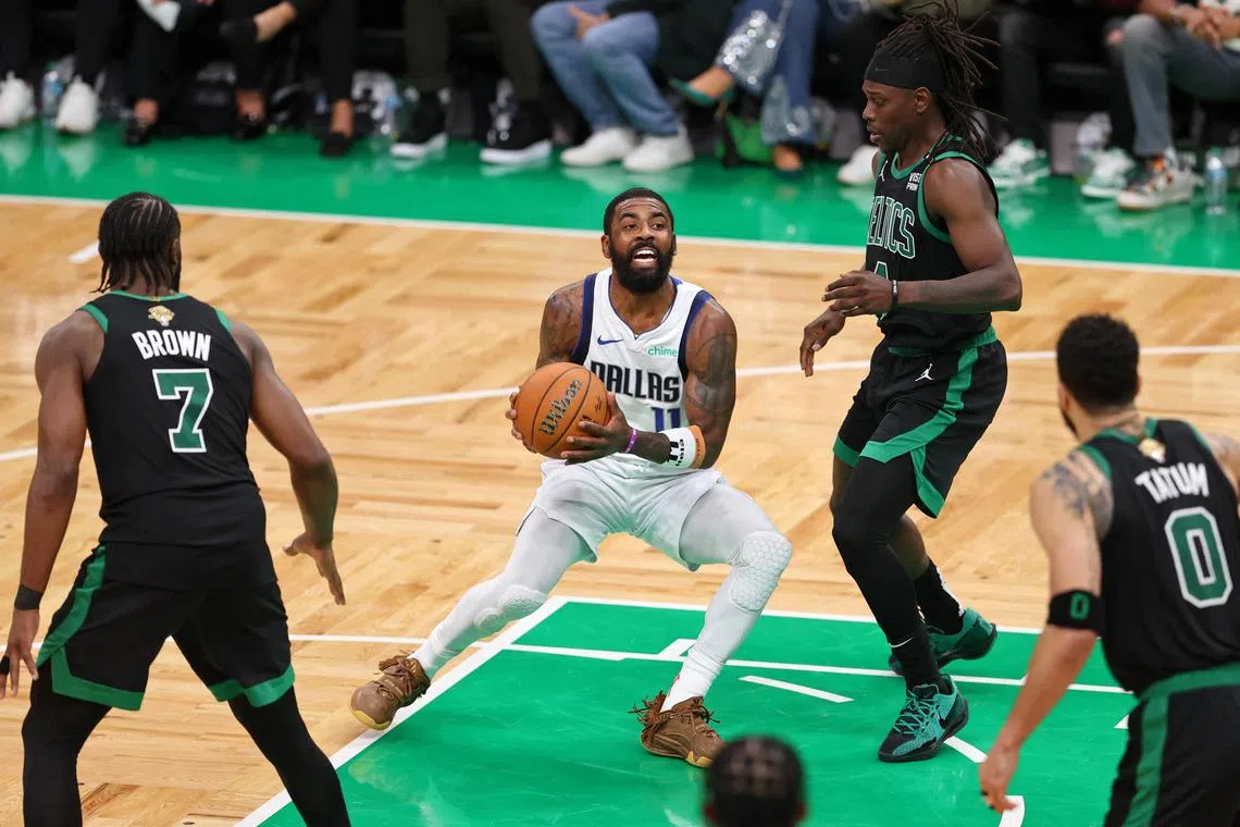 Dallas Mavericks guard Kyrie Irving controls the ball against Boston Celtics guard Jrue Holiday during the fourth quarter in Game 2 of the NBA Finals.