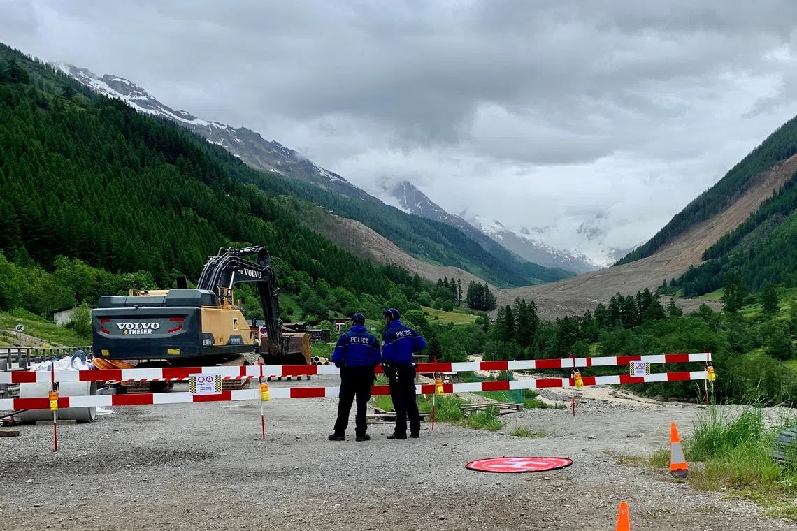FILE PHOTO: Police control the entry to the village, near the scene where a crumbling glacier partially collapsed and tumbled, at the village of Blatten, Switzerland June 2, 2025. REUTERS/Cecile Mantovani/File Photo