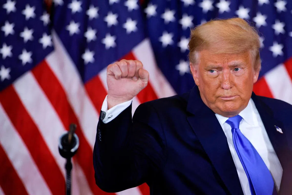 FILE PHOTO: U.S. President Donald Trump raises his fist as he reacts to early results from the 2020 U.S. presidential election in the East Room of the White House in Washington, U.S., November 4, 2020. REUTERS/Carlos Barria/File Photo