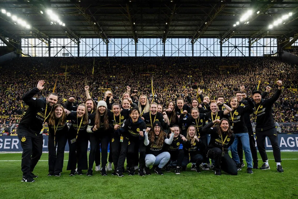 Singaporean footballer Danelle Tan celebrating with Borussia Dortmund women's team after winning the fifth-tier Landesliga title in Germany.