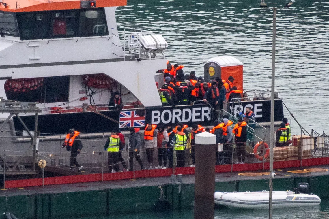 FILE PHOTO: Migrants disembark from a British Border Force vessel as they arrive at the Port of Dover, in Dover, Britain, December 29, 2024. REUTERS/Chris J. Ratcliffe/File Photo
