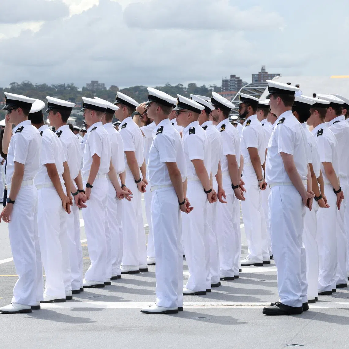 Sailors stand on board HMAS Canberra, facing the Sydney Opera House and the Sydney Harbour Bridge, ahead of the Kakadu International Fleet Review, a biennial maritime exercise marking 125 years of the Australian Navy, in Sydney, Australia, March 21, 2026. REUTERS/Hollie Adams