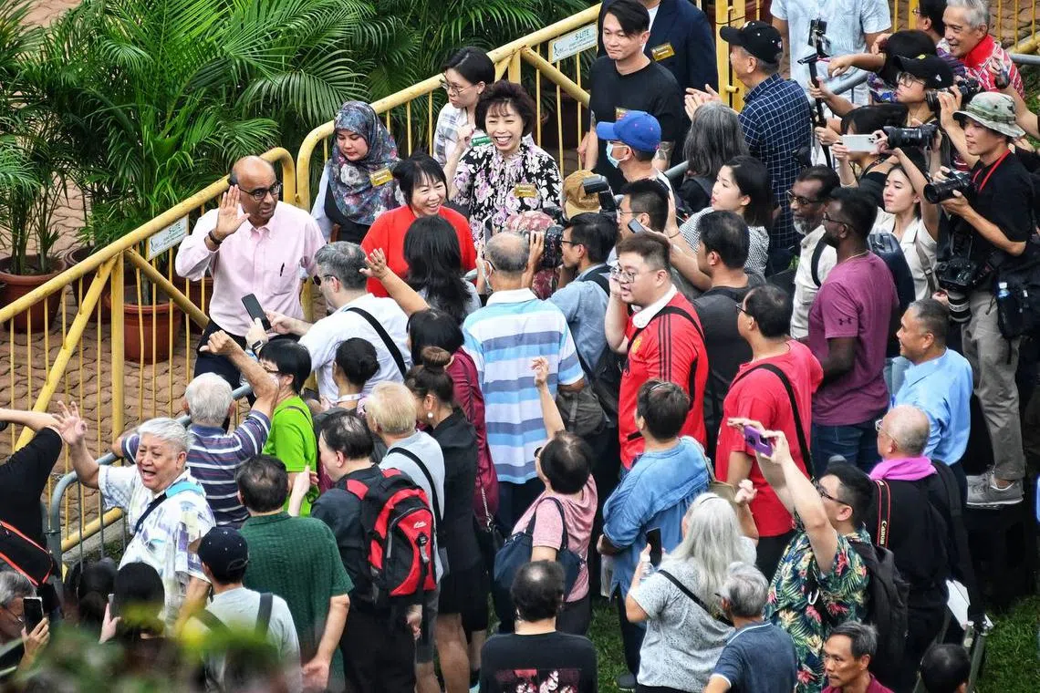 Tharman Shanmugaratnam and his wife, Jane Yumiko Ittogi, waving as they lave the nomination centre. 