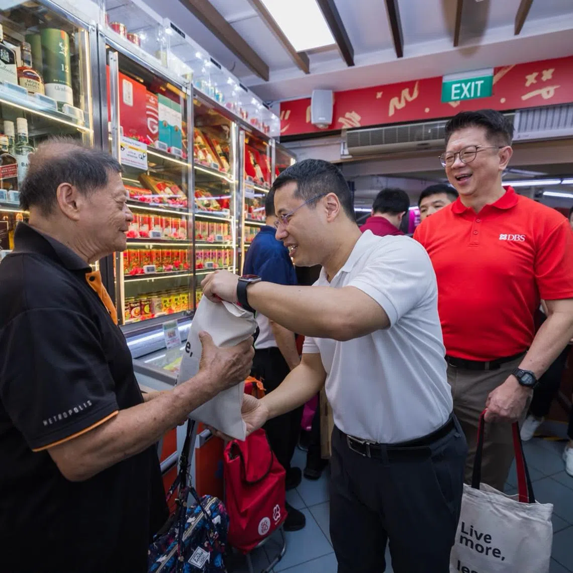 Education Minister Desmond Lee and DBS Singapore country head Lim Him Chuan distributing goodie bags containing everyday essentials to shoppers at Sheng Siong’s West Coast outlet during the launch of the DBS Saturday Savings programme on July 18.