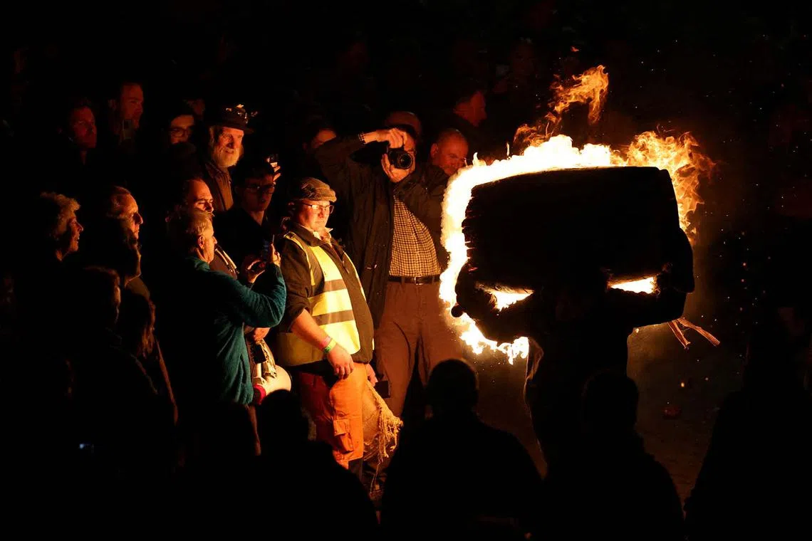 A participant carrying a flaming tar barrel through the street in Ottery St. Mary on Guy Fawkes night in Britain, Nov 5, 2024. 