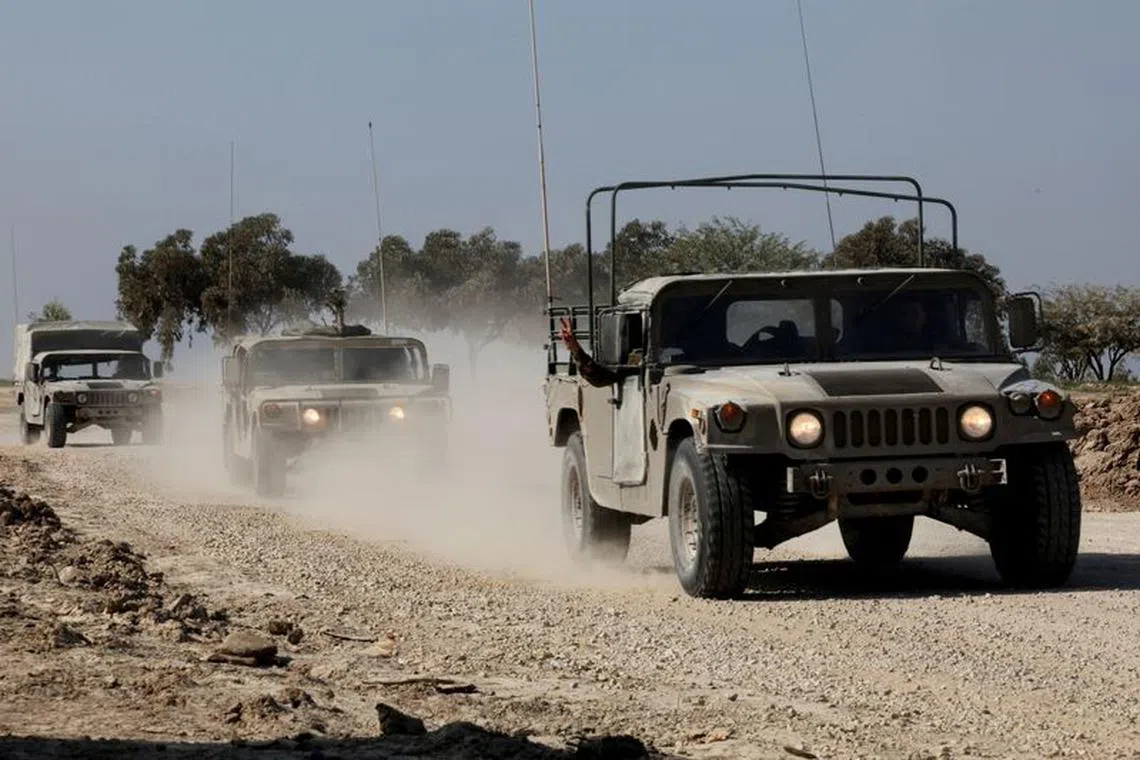 FILE PHOTO: Israeli military vehicles move near the Israel-Gaza border, amid the ongoing conflict between Israel and the Palestinian Islamist group Hamas, in southern Israel, December 31, 2023. REUTERS/Violeta Santos Moura/File Photo
