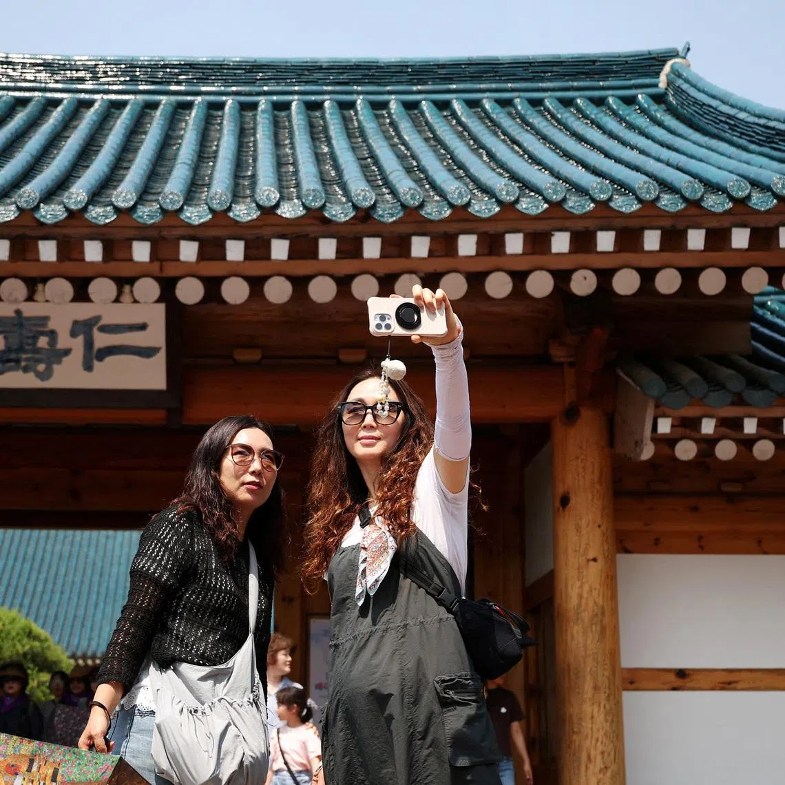 Women take a selfie in front of the presidential residence of the Blue House in Seoul.