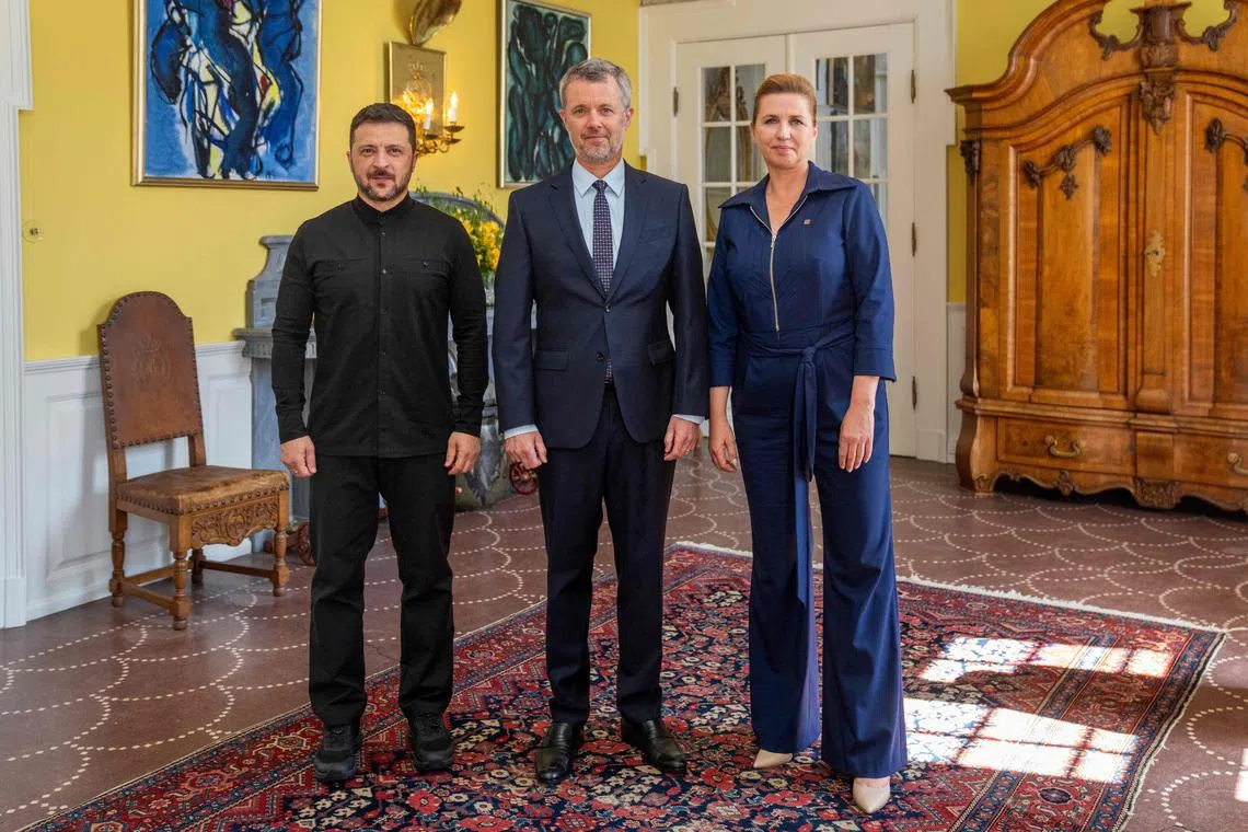 Ukrainian President Volodymyr Zelensky (left) is welcomed to Denmark on July 3 by Denmark's King Frederik and Danish Prime Minister Mette Frederiksen.