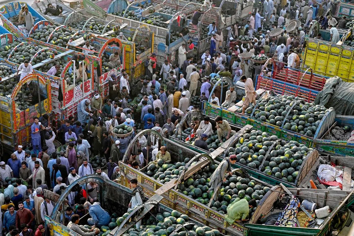 Customers buy watermelons at a fruit market in Lahore, Pakistan on April 7, 2025. 