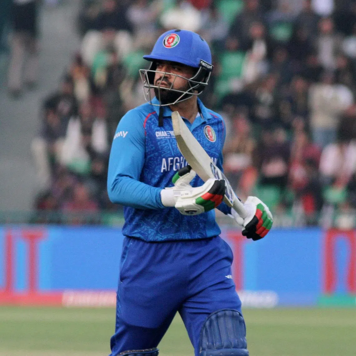 Cricket - ICC Men's Champions Trophy - Group B - Australia v Afghanistan - Gaddafi Stadium, Lahore, Pakistan - February 28, 2025  Afghanistan's Rashid Khan walks after losing his wicket, caught by Australia's Glenn Maxwell off the bowling of Ben Dwarshuis REUTERS/Asim Tanveer