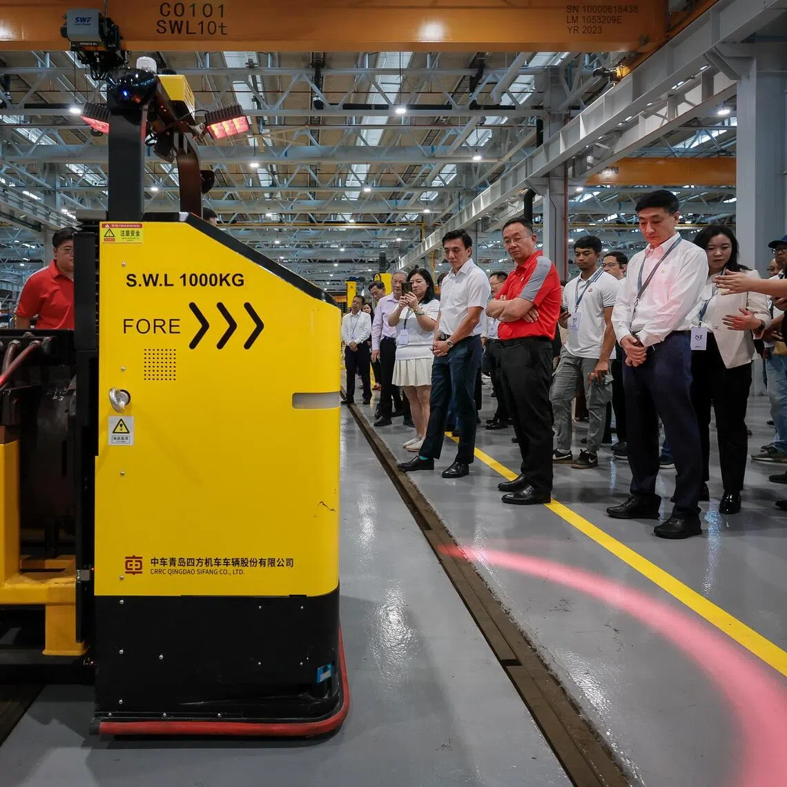 Acting Transport Minister Jeffrey Siow (in short-sleeved white shirt) observing an automated guided vehicle (AGV) at the launch of Depot 4.0 at Bishan Depot on Nov 21.