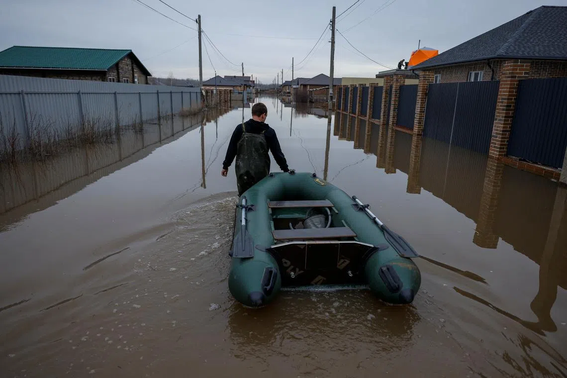 FILE PHOTO: A man tows an inflatable boat along a flooded street in in the settlement of Ivanovskoye, Orenburg region, Russia, April 10, 2024. REUTERS/Maxim Shemetov/File Photo
