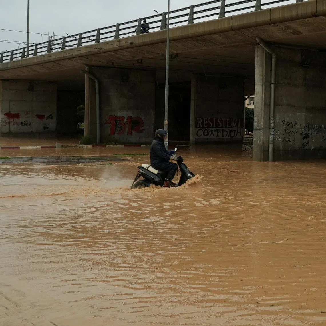 A person rides a motorcycle through a flooded street as torrential rains hit the country, in Tunis, Tunisia January 20, 2026. REUTERS/Jihed Abidellaoui