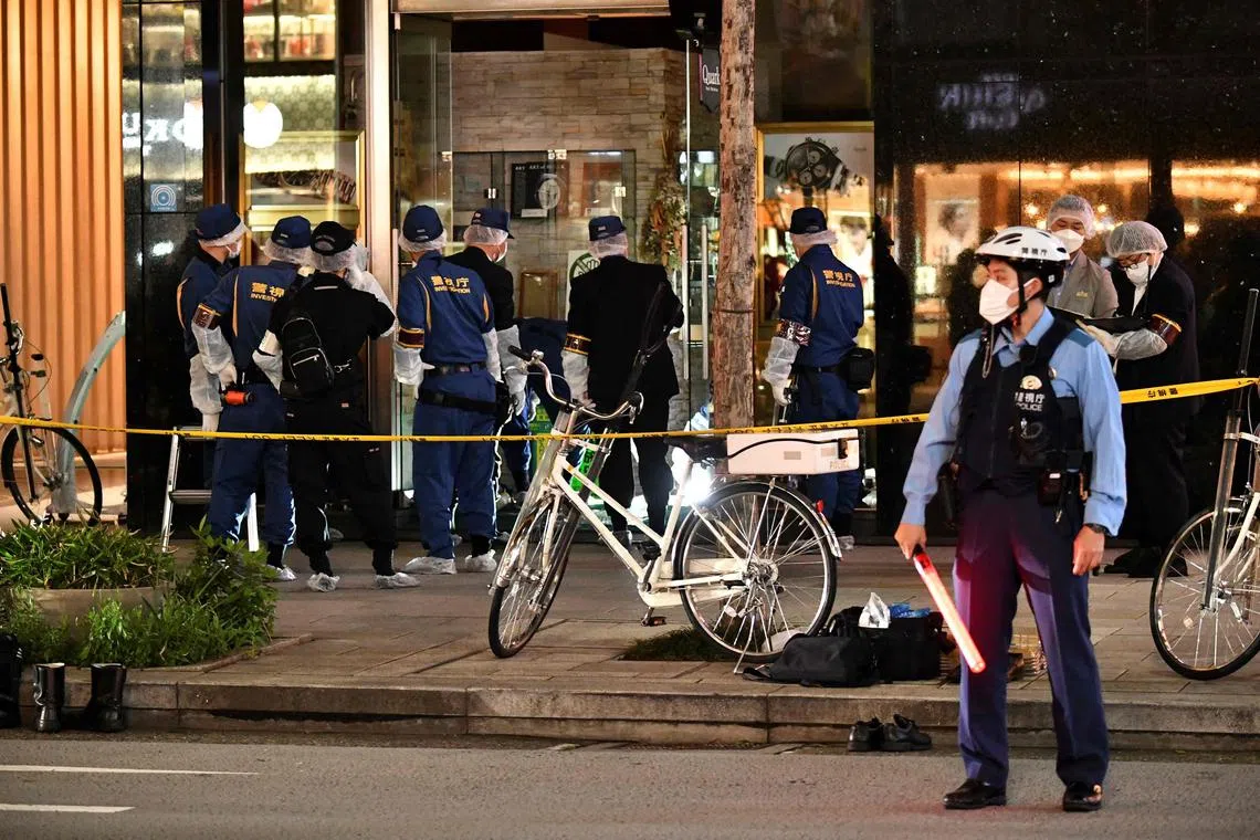 Police officers conduct investigations at the crime scene following the robbery of a luxury watch store in Tokyo's Ginza shopping district on Monday. 