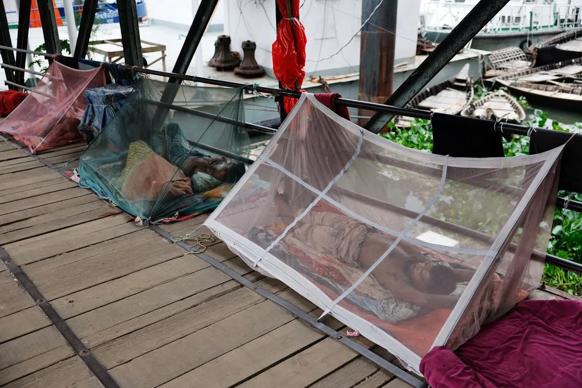 FILE PHOTO: People sleep using mosquito nets, following a surge of dengue-infected patients, in Dhaka, Bangladesh, June 25, 2025. REUTERS/Mohammad Ponir Hossain/File Photo