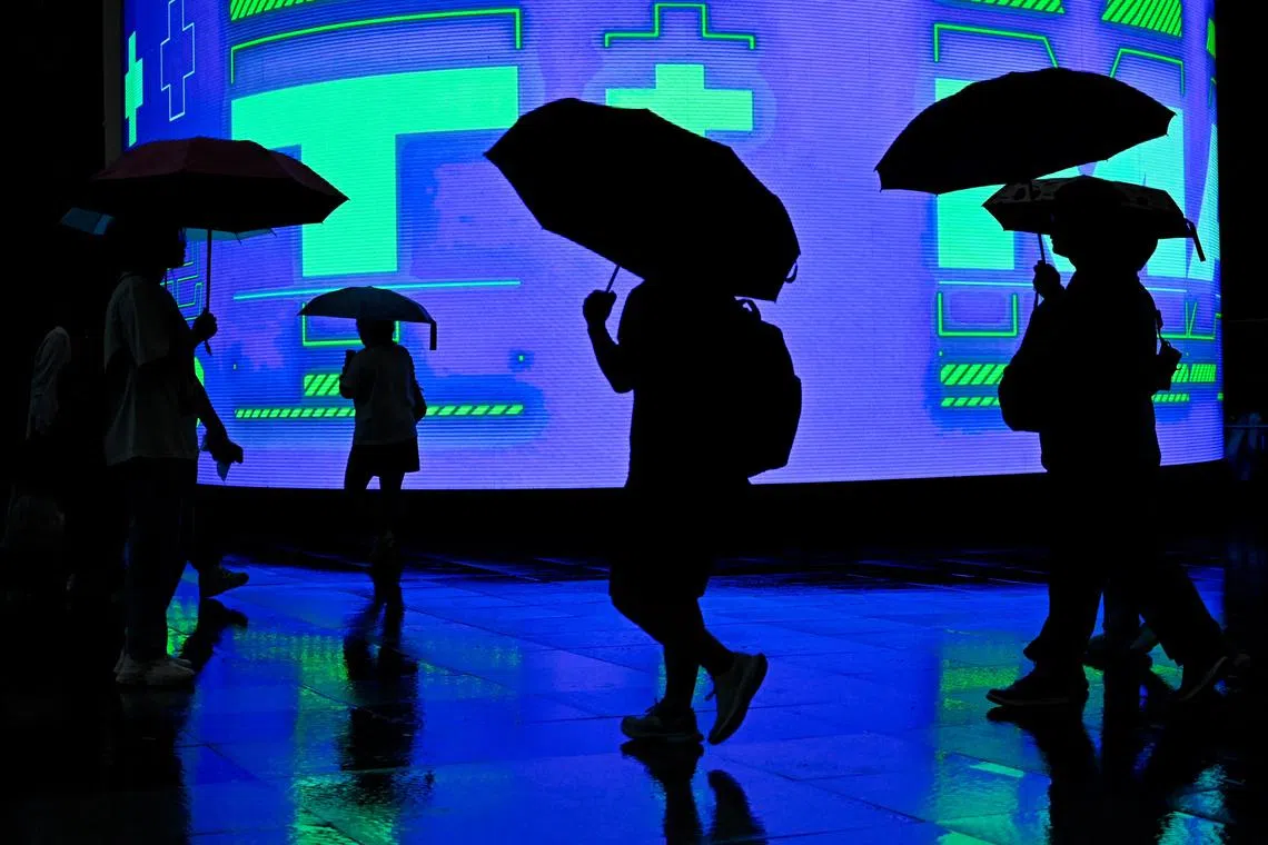 People with umbrellas walking during a rainstorm in Beijing on July 30, 2024. 