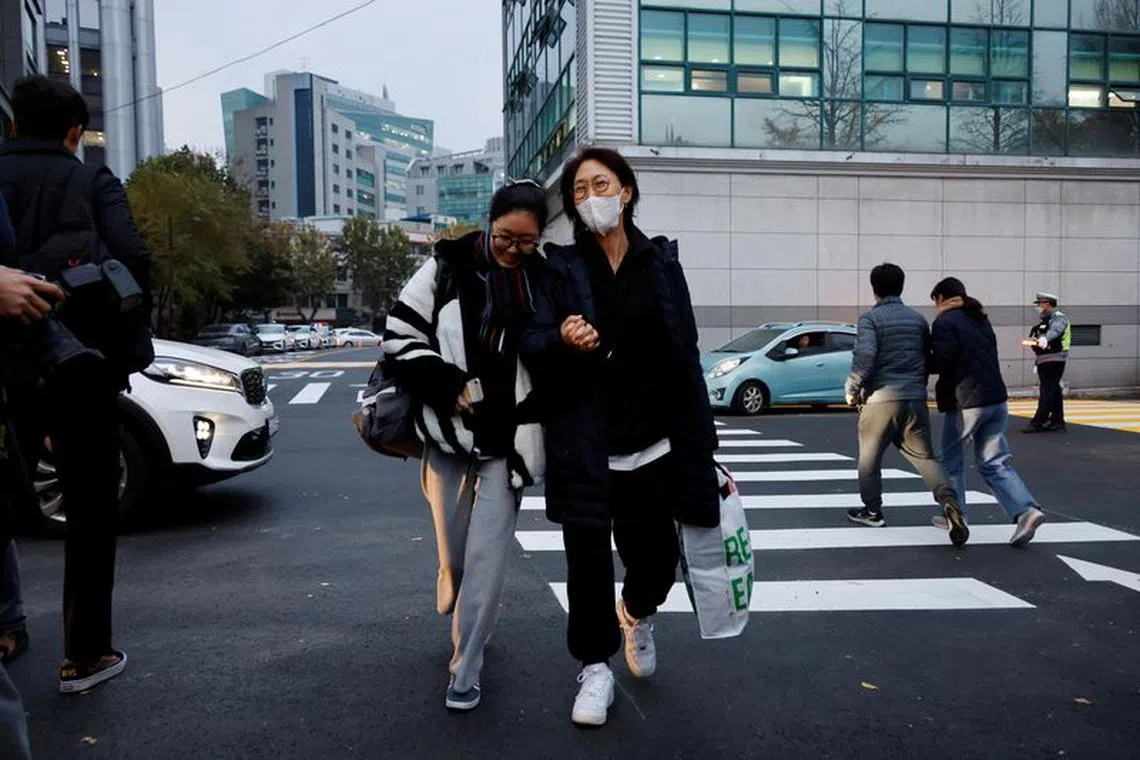 A mother holds her daughter's hand as she takes the College Scholastic Ability Test in Seoul, South Korea, November 16, 2023.   REUTERS/Kim Soo-hyeon