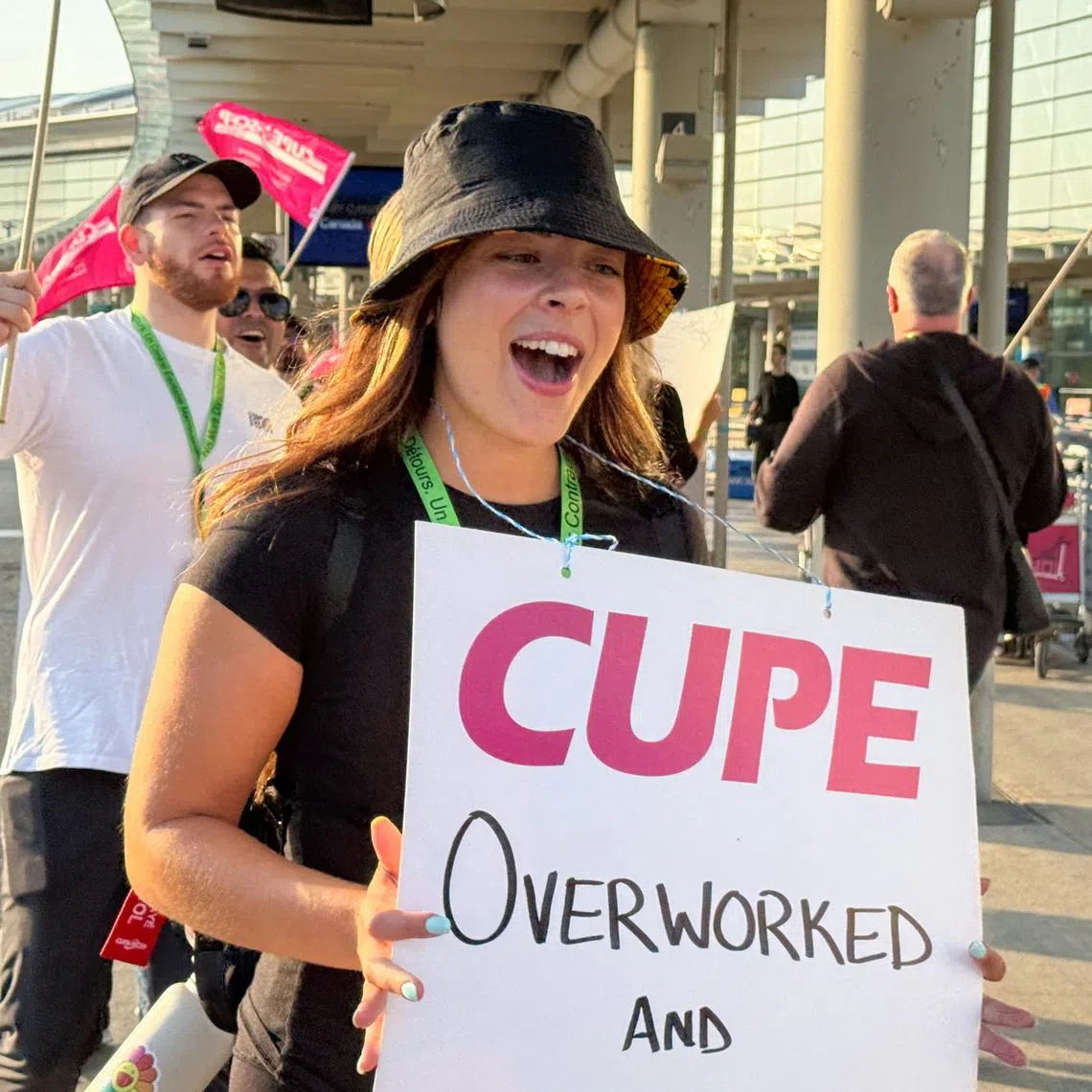 People hold picket signs outside Terminal 1 as a strike begins after the union representing Air Canada's 10,000 flight attendants failed to reach an agreement with the airline, at Toronto Pearson International Airport in Mississauga, Ontario, Canada August 16, 2025.  REUTERS/Kyaw Soe Oo