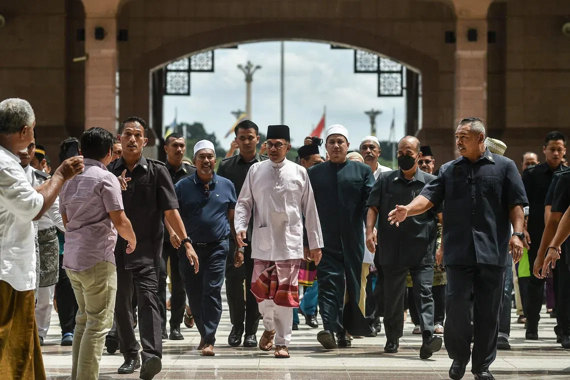 Malaysia's Prime Minister Anwar Ibrahim (C) leaves Putra Mosque after prayers in Putrajaya, on November 25, 2020. (Photo by Arif Kartono / AFP)