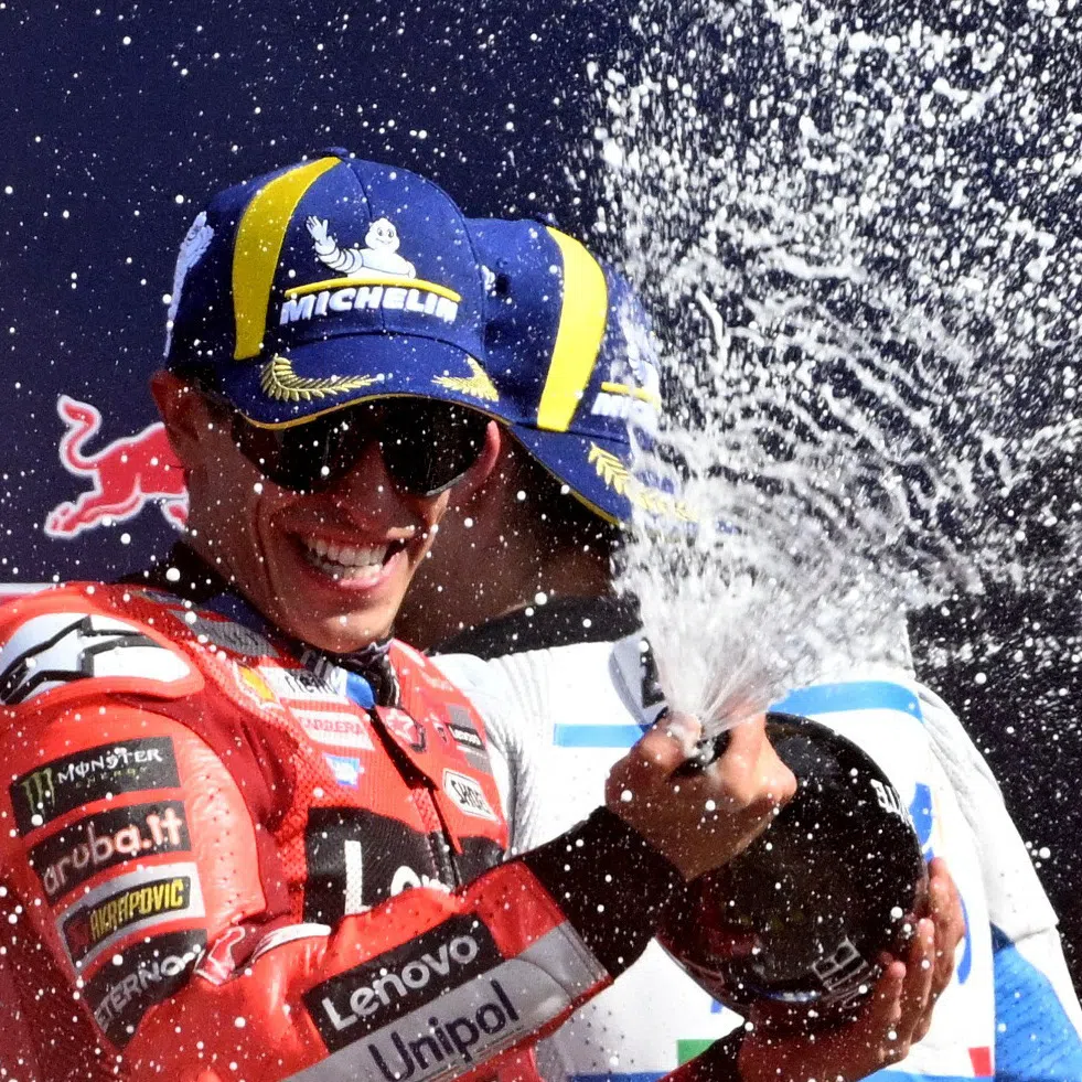 MotoGP - San Marino Grand Prix - Misano World Circuit Marco Simoncelli, Misano, Italy - Spetember 14, 2025 Ducati Lenovo Team's Marc Marquez celebrates on the podium after winning the San Marino Grand Prix with third placed BK8 Gresini Racing MotoGP's Alex Marquez REUTERS/Jennifer Lorenzini