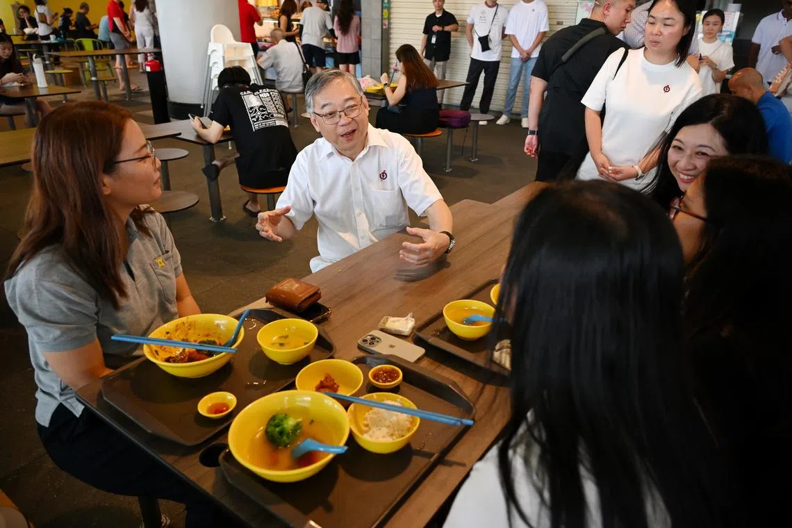 DPM Gan Kim Yong speaking to residents during a walkabout at One Punggol Hawker Centre on April 29.