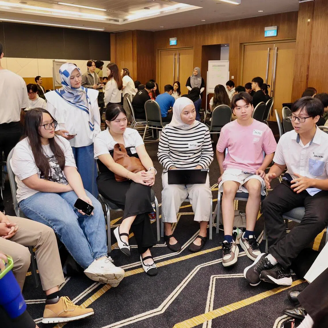 Youth participants, along with Minister of State for Digital Development and Information Rahayu Mahzam, discussing how social media should be regulated in Singapore at an engagement session organised by the ministry on July 4.
