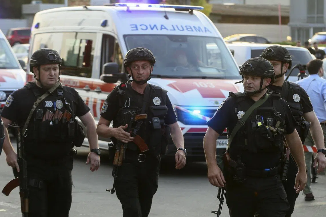 Armed Ukrainian police officers keep watch, after an explosion at a court in Kyiv.